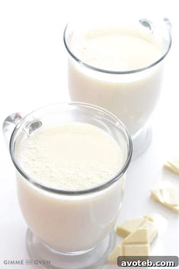 Creamy homemade white hot chocolate topped with whipped cream, perfect for a cozy winter evening.