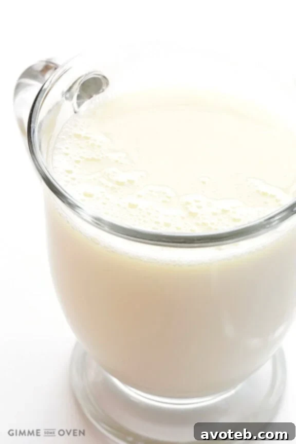 Close-up of a steaming mug of homemade white hot chocolate, garnished with whipped cream and white chocolate curls.