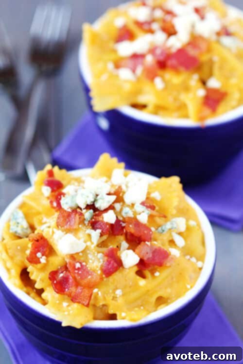 Creamy Butternut Squash, Bacon & Blue Cheese Macaroni & Cheese in a serving bowl, garnished with bacon and blue cheese crumbles