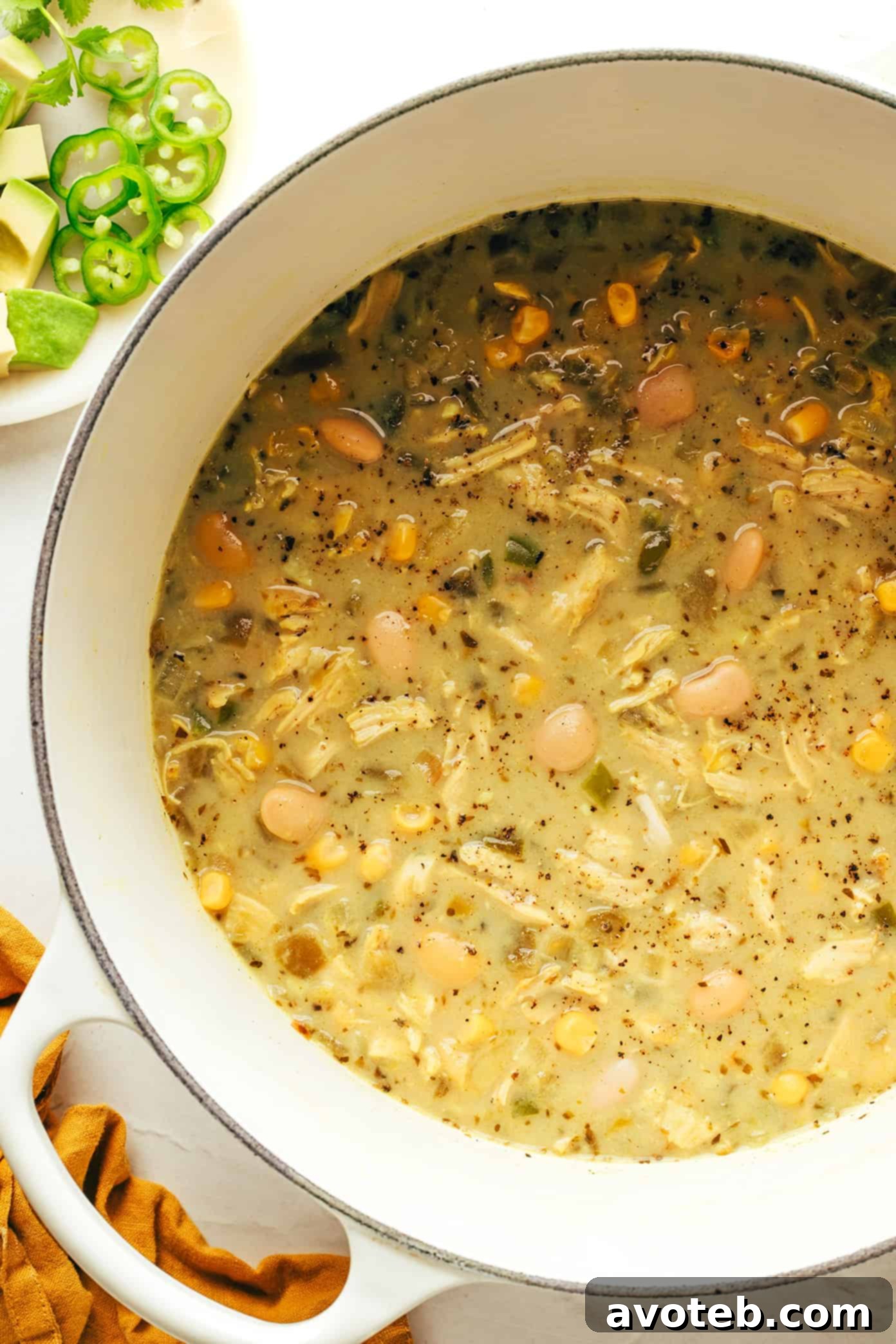 Top-down view of white chicken chili with tortilla chips and cilantro.