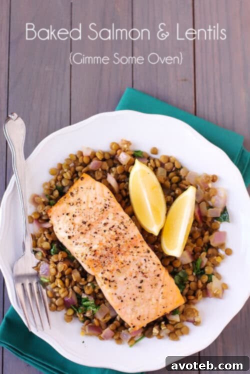 Close-up of baked salmon served over a bed of mildly spiced lentils, garnished with fresh cilantro and a lemon wedge.