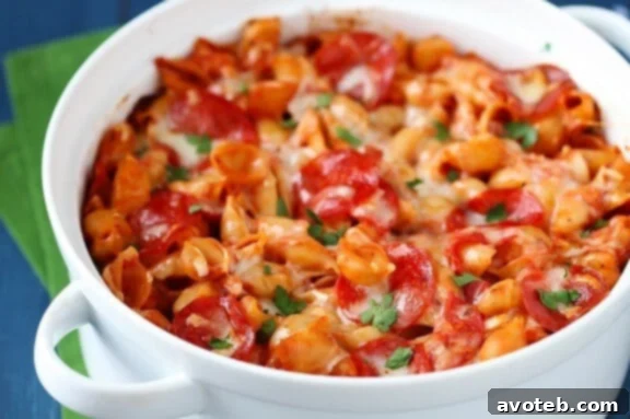 Close-up of baked pepperoni pasta with melted cheese and basil garnish.