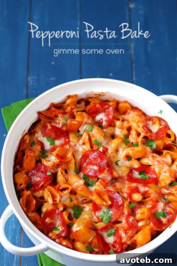 A large serving of pepperoni pasta bake on a white plate, ready to eat.