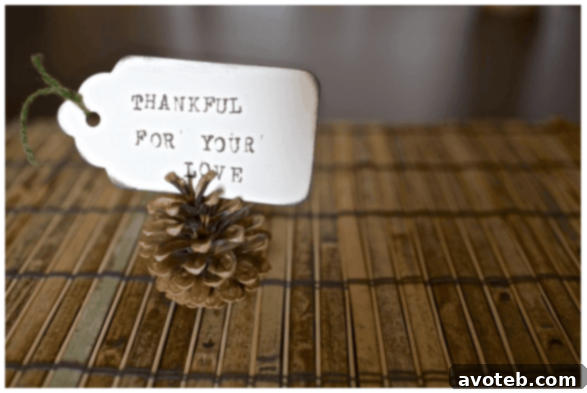 DIY Pinecone Place Cards on a rustic holiday table setting with cranberries and greenery