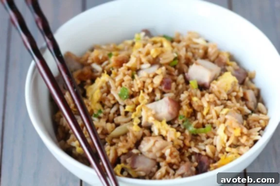 Delicious Pork Fried Rice, a classic Asian comfort food dish, served with a vibrant garnish.