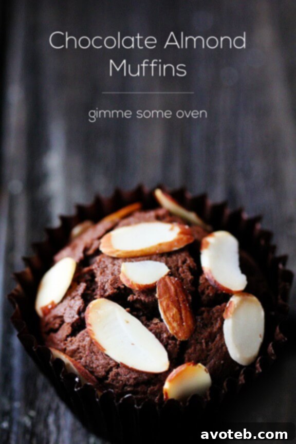 A hand reaching for a warm Chocolate Almond Muffin from a basket, highlighting its inviting texture.