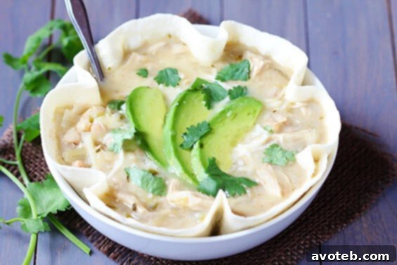 Creamy White Chicken Chili served in a bowl, garnished with fresh cilantro and a lime wedge.