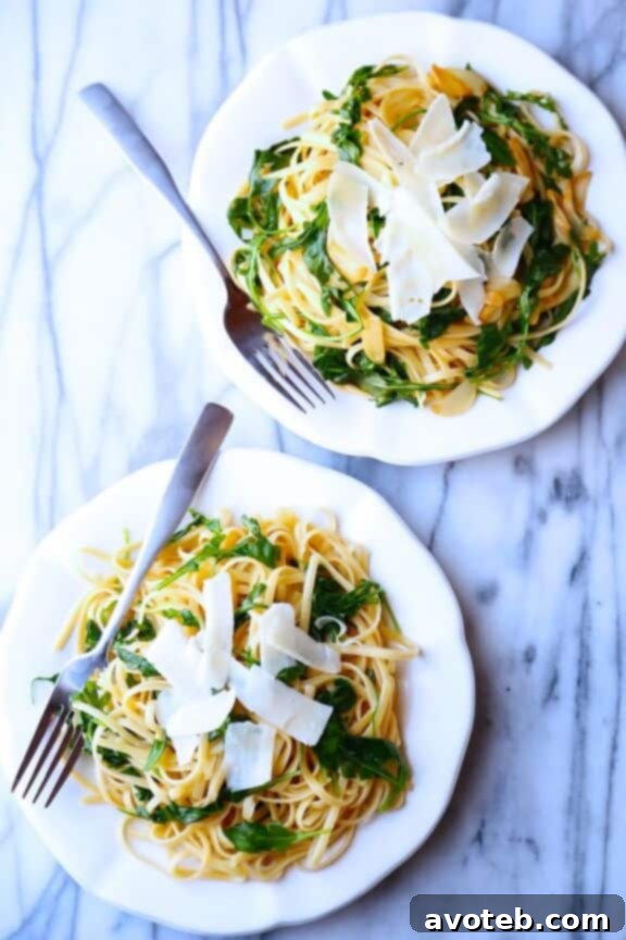 Close-up view of freshly tossed Linguine with Arugula, Garlic & Parmesan, showing wilted arugula leaves