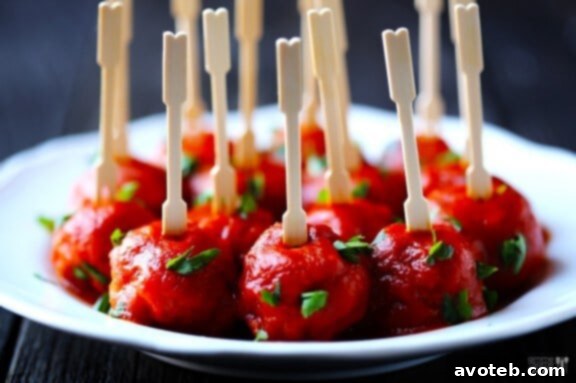 Close-up of a meatball being dipped in smoky sauce