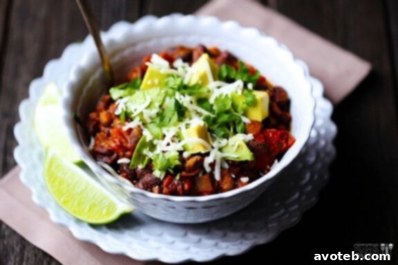 A close-up shot of Smoky Black Bean Chili, garnished with fresh cilantro and avocado, ready to be enjoyed.