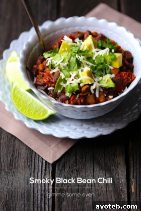Overhead view of Smoky Black Bean Chili in a rustic bowl with various toppings, emphasizing its hearty appeal.
