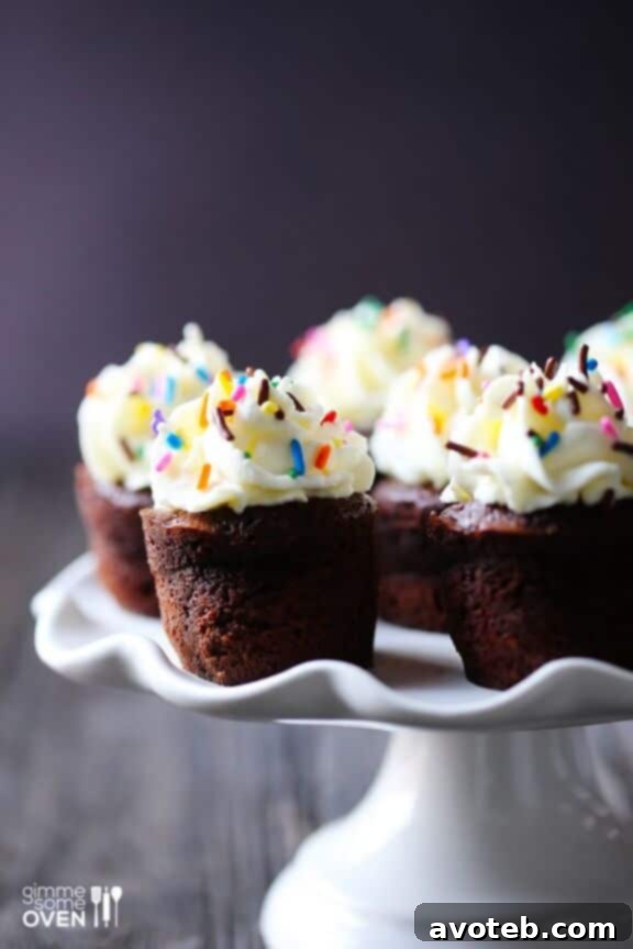 Mini Flourless Chocolate Cakes topped with whipped cream and sprinkles, ready to serve.