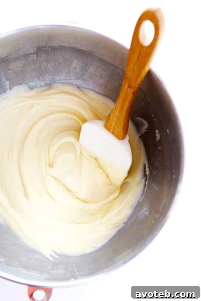 A batch of pumpkin cookie dough being scooped onto a baking sheet lined with parchment paper, ready for baking.