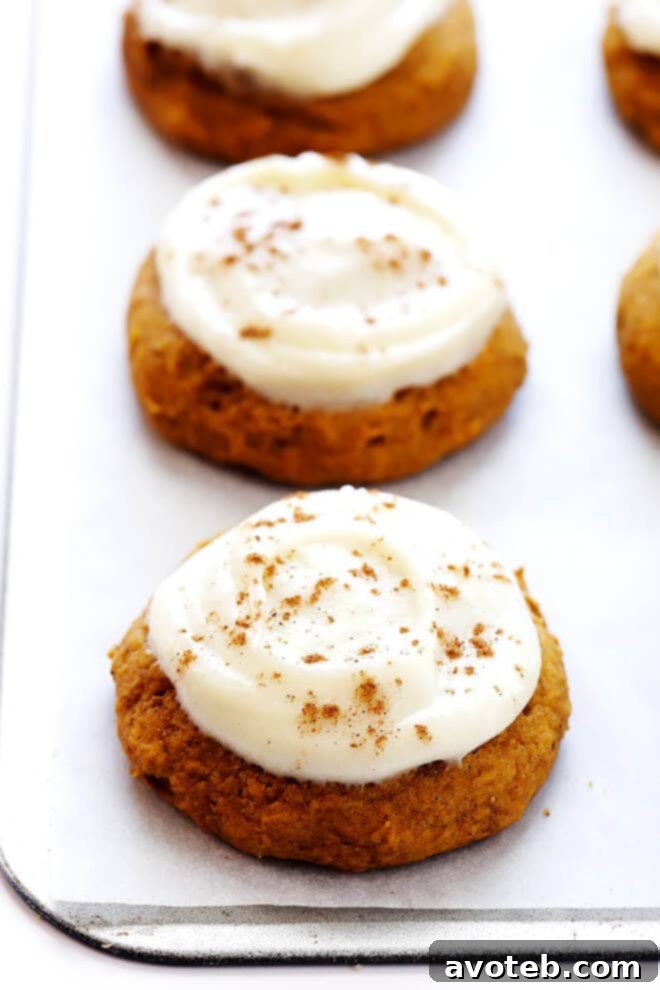 A bowl of freshly made, smooth, white cream cheese frosting, ready to be spread on pumpkin cookies.