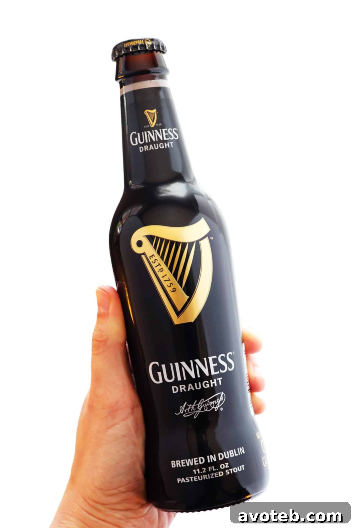 A bottle of Guinness beer next to a serving of hearty beef stew, highlighting the key ingredient for its rich flavor.
