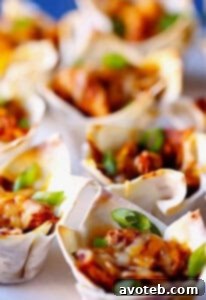 Crispy wonton cups filled with savory chicken and melted cheese, a perfect bite-sized appetizer.
