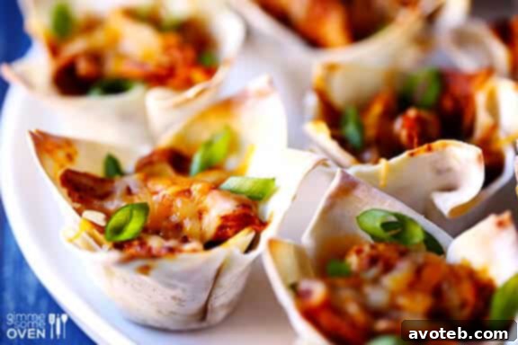 Mini Chicken Enchilada Bites 7 Three Chicken Enchilada Cups on a wooden board, showcasing their golden crust and savory filling.