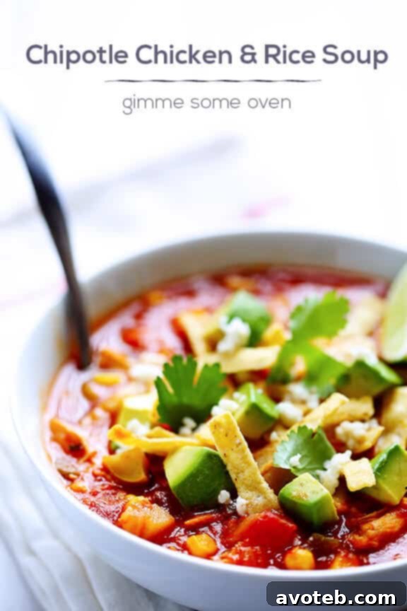A warm bowl of spicy Chipotle Chicken and Rice Soup on a rustic table