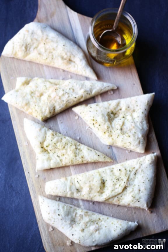 A hand reaching for a slice of the Easy Italian Flatbread, emphasizing its deliciousness.