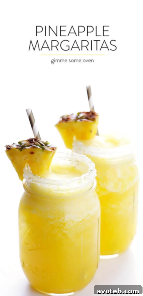 A vibrant Fresh Pineapple Margarita garnished with a pineapple wedge and a lime slice, set against a blurred background, inviting a refreshing sip.