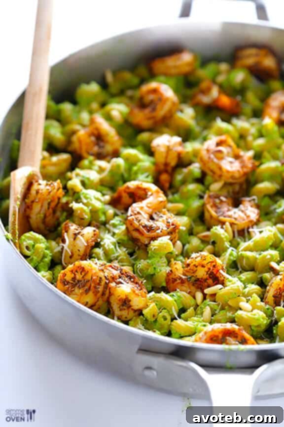 Asparagus-spinach pesto pasta with blackened shrimp garnished with Parmesan.