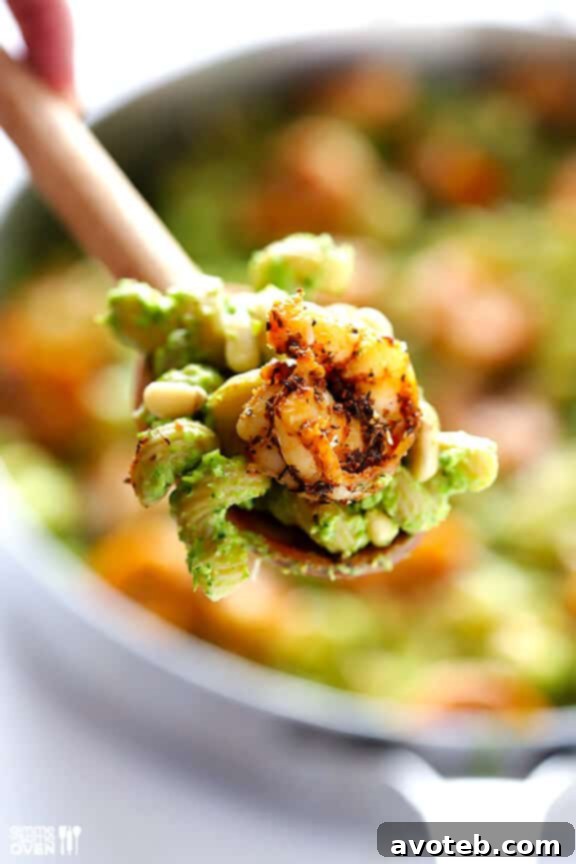 A serving of asparagus-spinach pesto pasta with blackened shrimp.