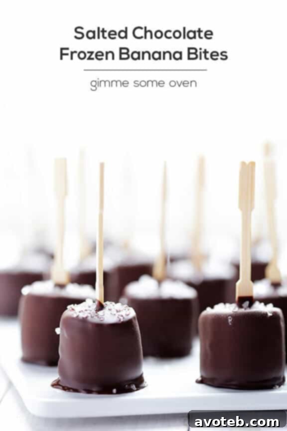 Hand holding a Salted Chocolate Frozen Banana Bite, showing the chocolate shell and salt