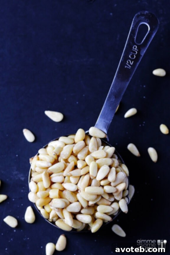 Close-up of Arugula Pesto Pasta, garnished with pine nuts and Parmesan.
