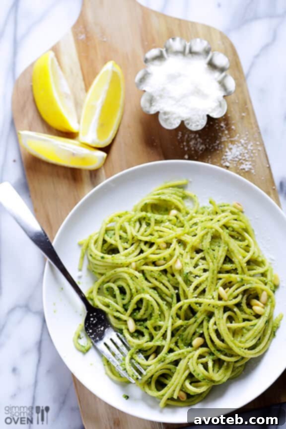 The process of making fresh arugula pesto in a food processor.