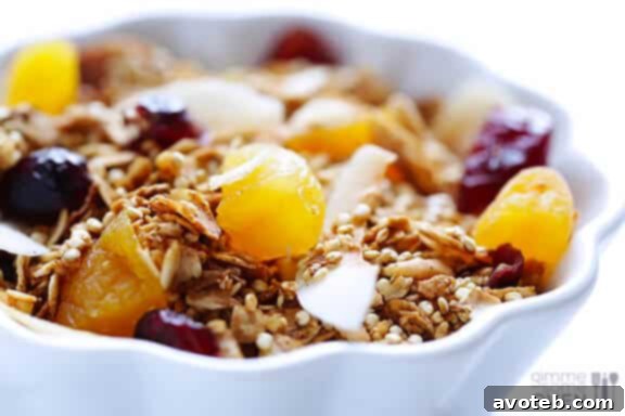 Hand scooping fresh Quinoa Granola from a bowl
