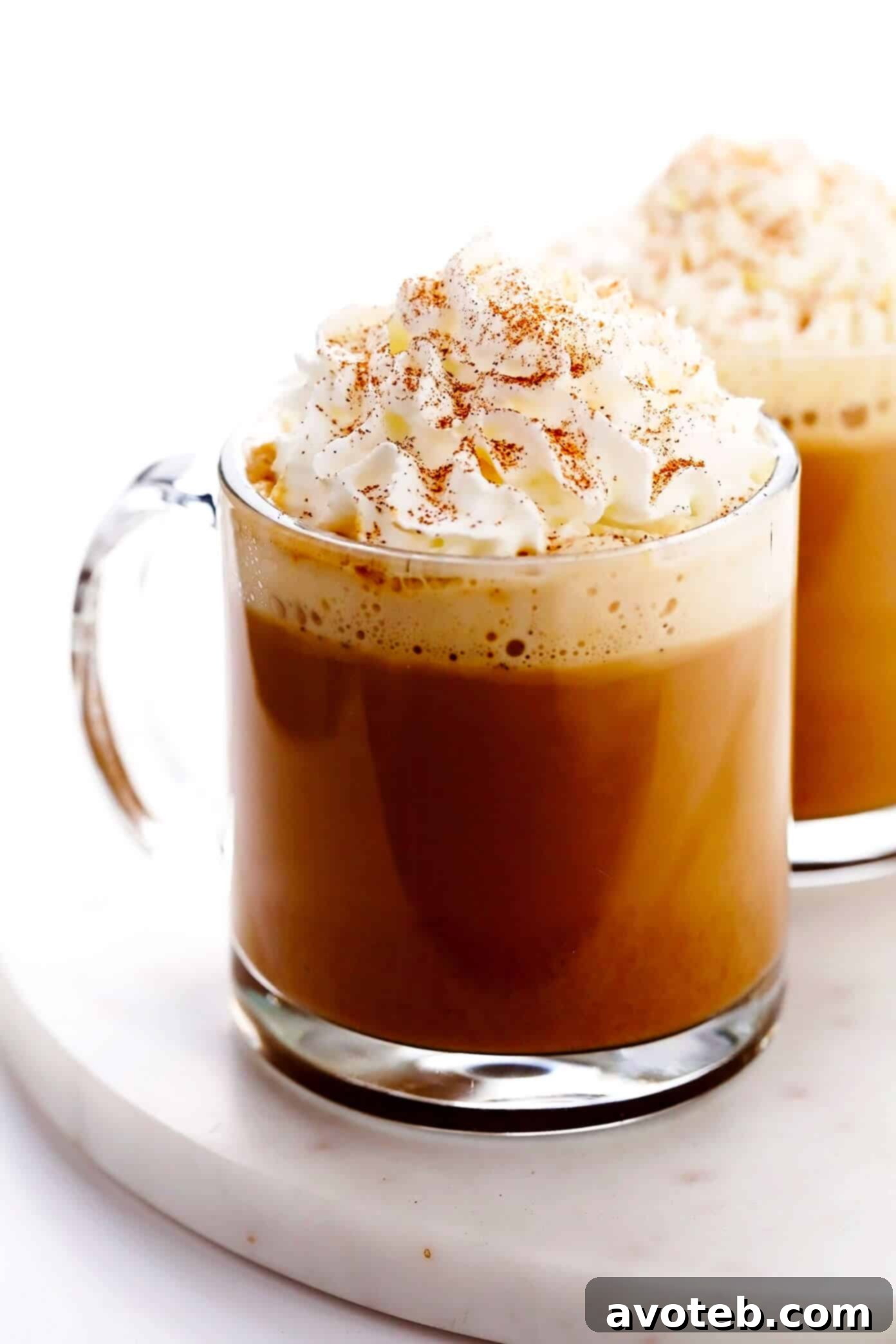 Homemade Pumpkin Spice Latte, topped generously with whipped cream and a delicate sprinkle of pumpkin pie spice.