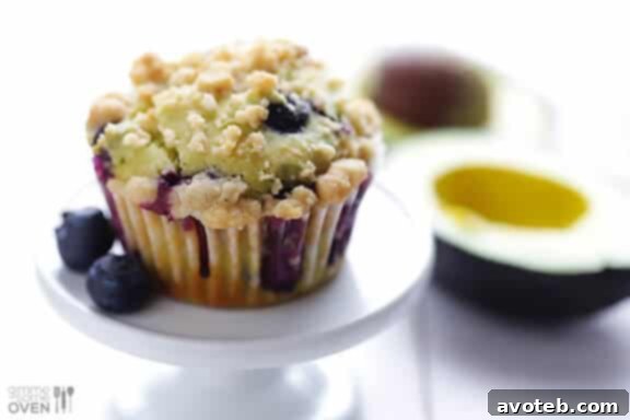 A selection of blueberry avocado muffins presented on a rustic wooden board, highlighting their inviting texture and fresh blueberries.
