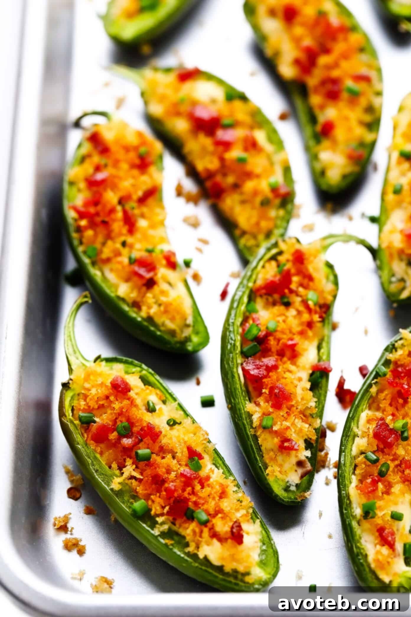 Creamy cheese filling being piped into fresh jalapeno halves