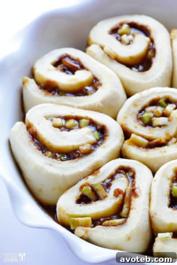 The rolled-out dough covered with softened butter, cinnamon sugar, chopped apples, and caramel sauce.