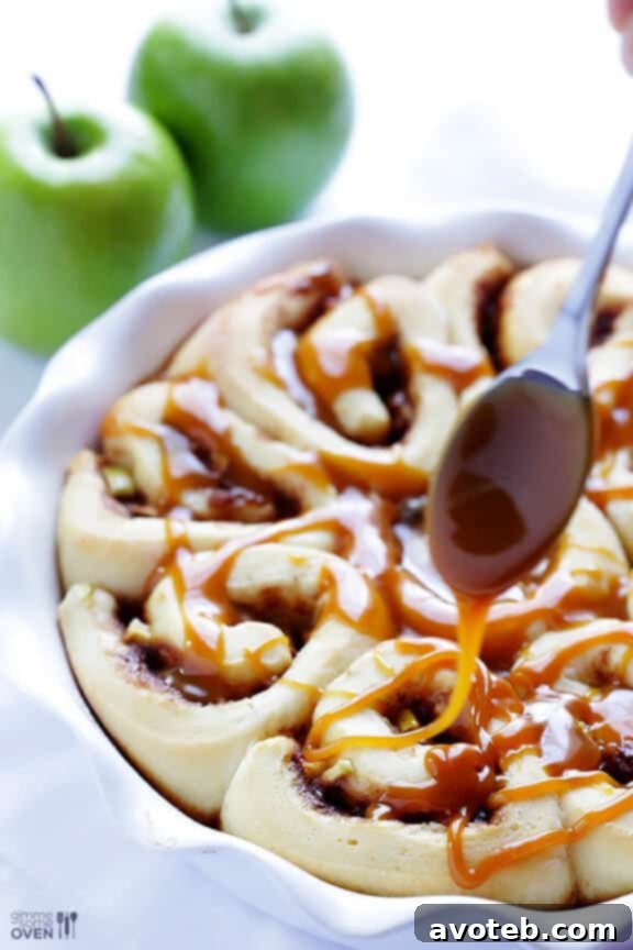 Individual caramel apple cinnamon rolls arranged in a greased baking dish before rising.