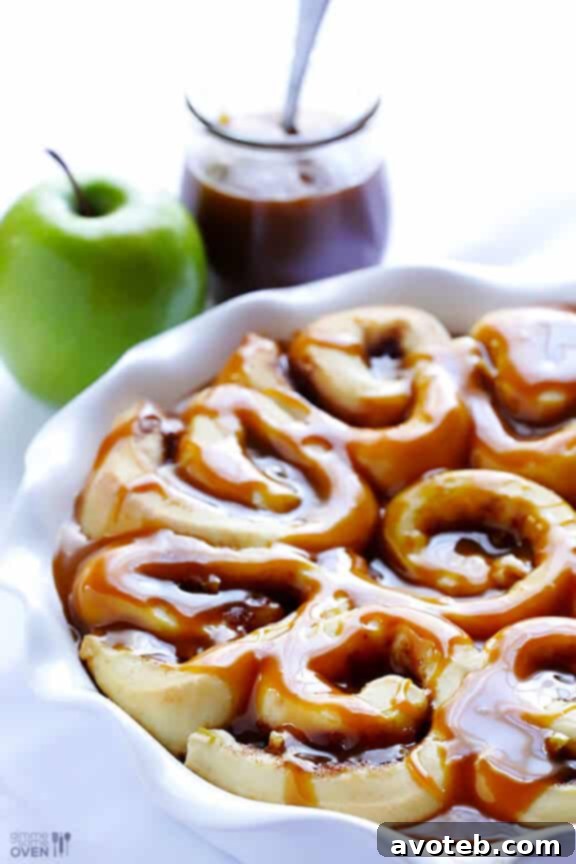 Rising caramel apple cinnamon rolls, visibly puffed up and ready for baking.