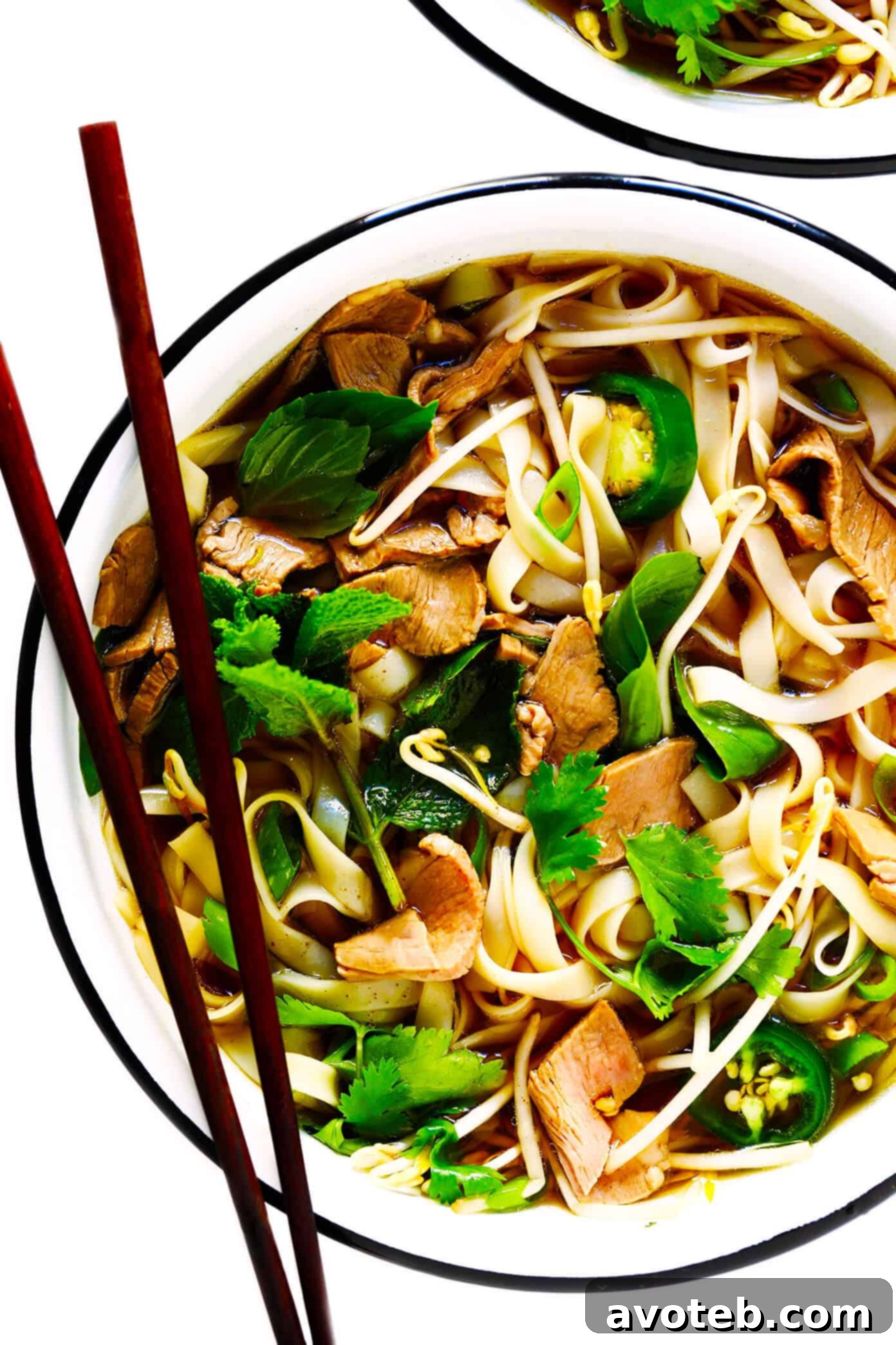 Aromatic Vietnamese Beef Pho Soup, garnished with fresh herbs and lime.