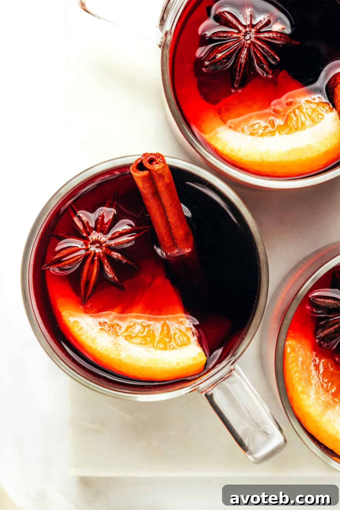 Mulled wine served in elegant glass mugs, steam rising, with a cozy, festive background, highlighting a perfect winter drink.
