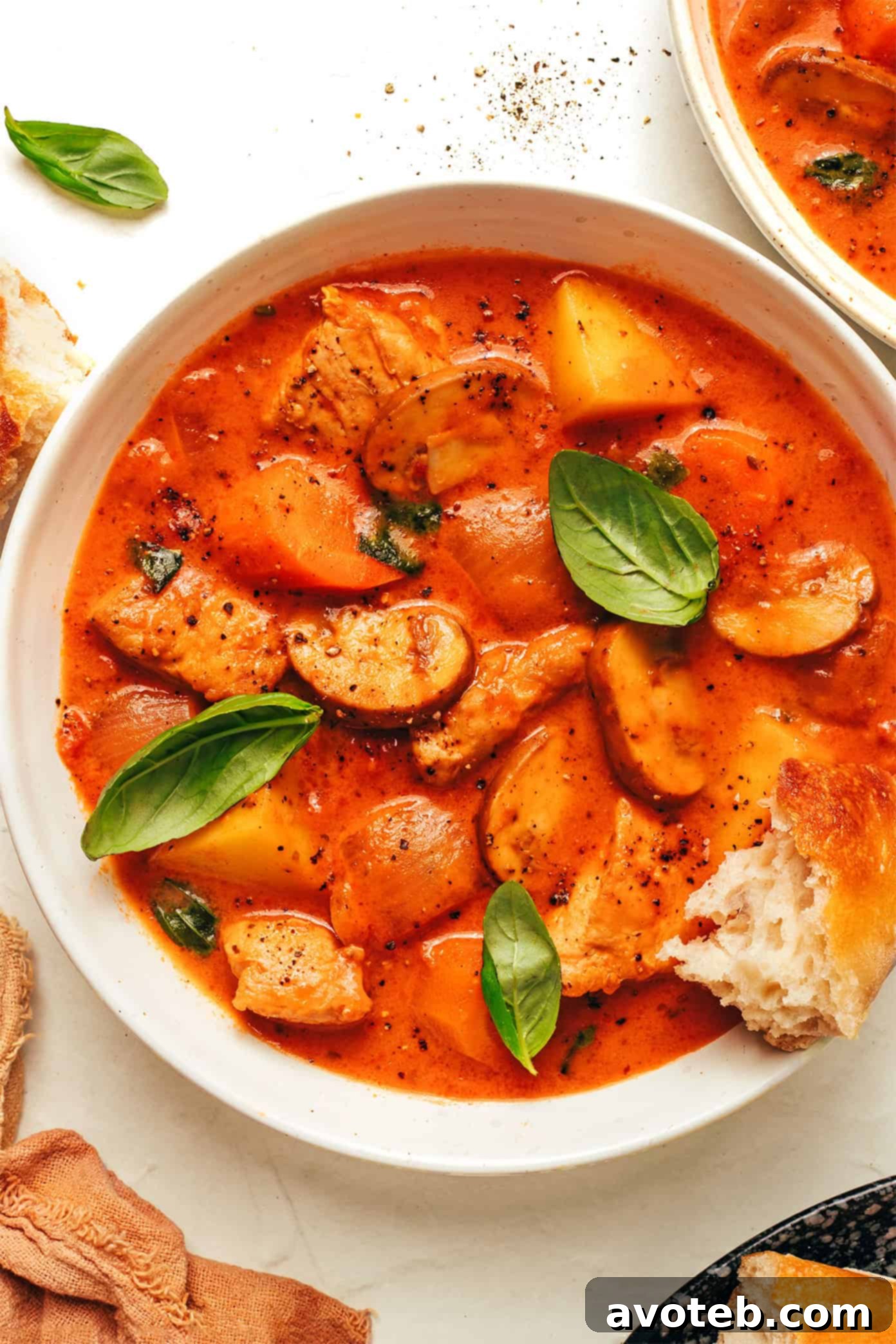 tomato basil chicken stew in bowl with bread