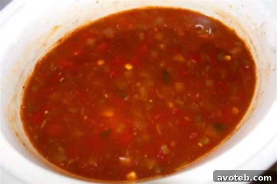 Chicken Tortilla Soup simmering in a slow cooker, ready to be served.