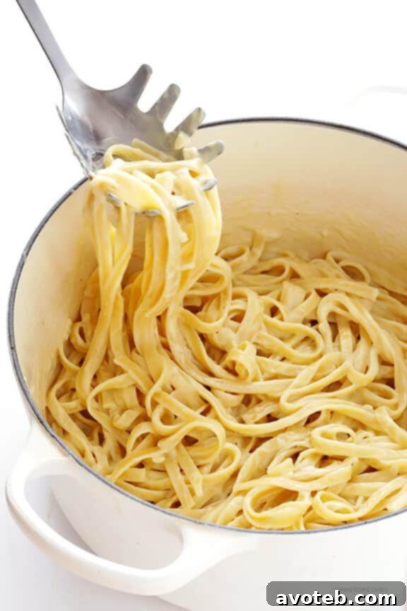 Tossing fettuccine with light Alfredo sauce