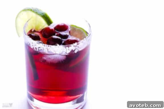 Vibrant Cranberry Margaritas garnished with fresh cranberries and lime slices, a perfect festive cocktail.