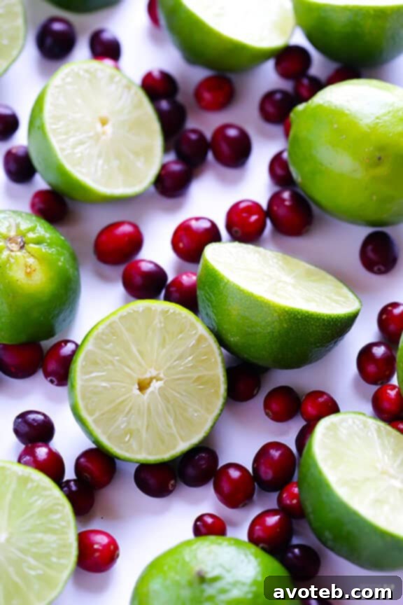Cranberry Margarita ingredients being poured into a pitcher, highlighting the rich red color of cranberry juice.
