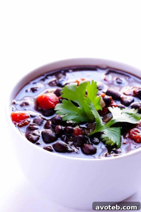 Overhead shot of a bowl of 5-Ingredient Black Bean Soup with a spoon, highlighting its texture.