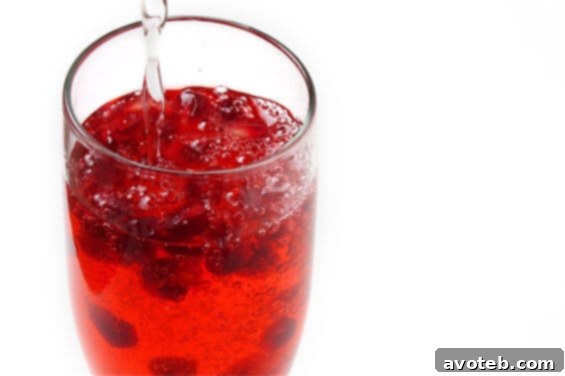 Elegant Pomegranate Champagne cocktail in a flute glass, garnished with fresh pomegranate seeds, a perfect festive drink.