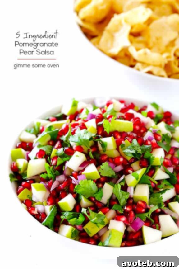 A beautiful shot of the Pear Pomegranate Salsa served in a clear bowl with a spoon, highlighting its festive appearance and fresh ingredients, ready for any occasion.