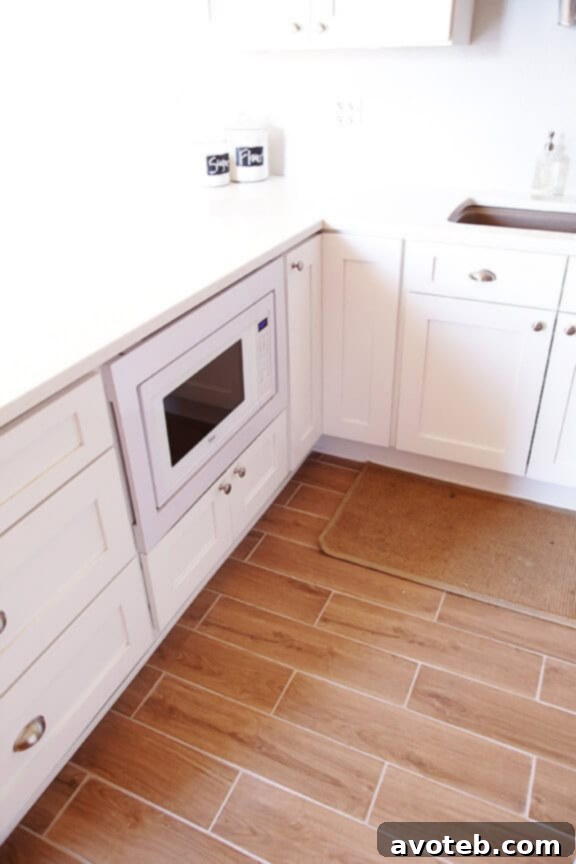 Durable wood-grain tile flooring contrasting with white kitchen cabinets