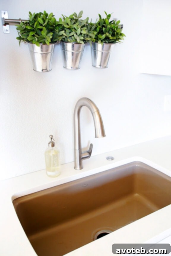 Elegant Kohler cast-iron sink with a modern touch-free faucet in a white kitchen