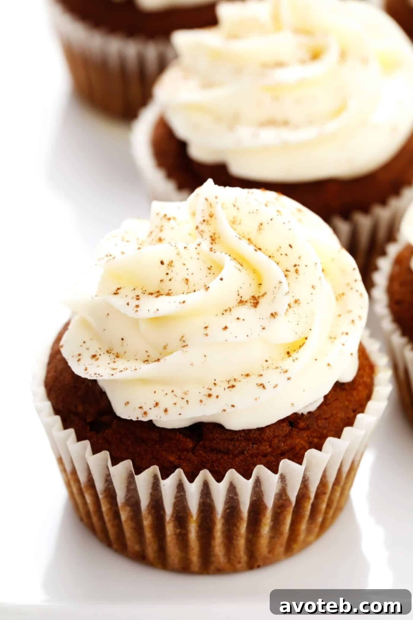 Delicious Pumpkin Cupcakes topped with creamy white cream cheese frosting, ready for a fall celebration.