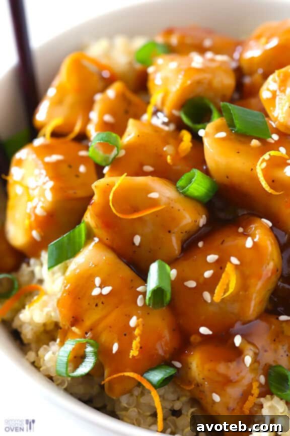 Skinny Orange Chicken Recipe | gimmesomeoven.com #newyears #chicken #recipe Beautifully plated Skinny Orange Chicken served over quinoa, garnished with green onions and sesame seeds.